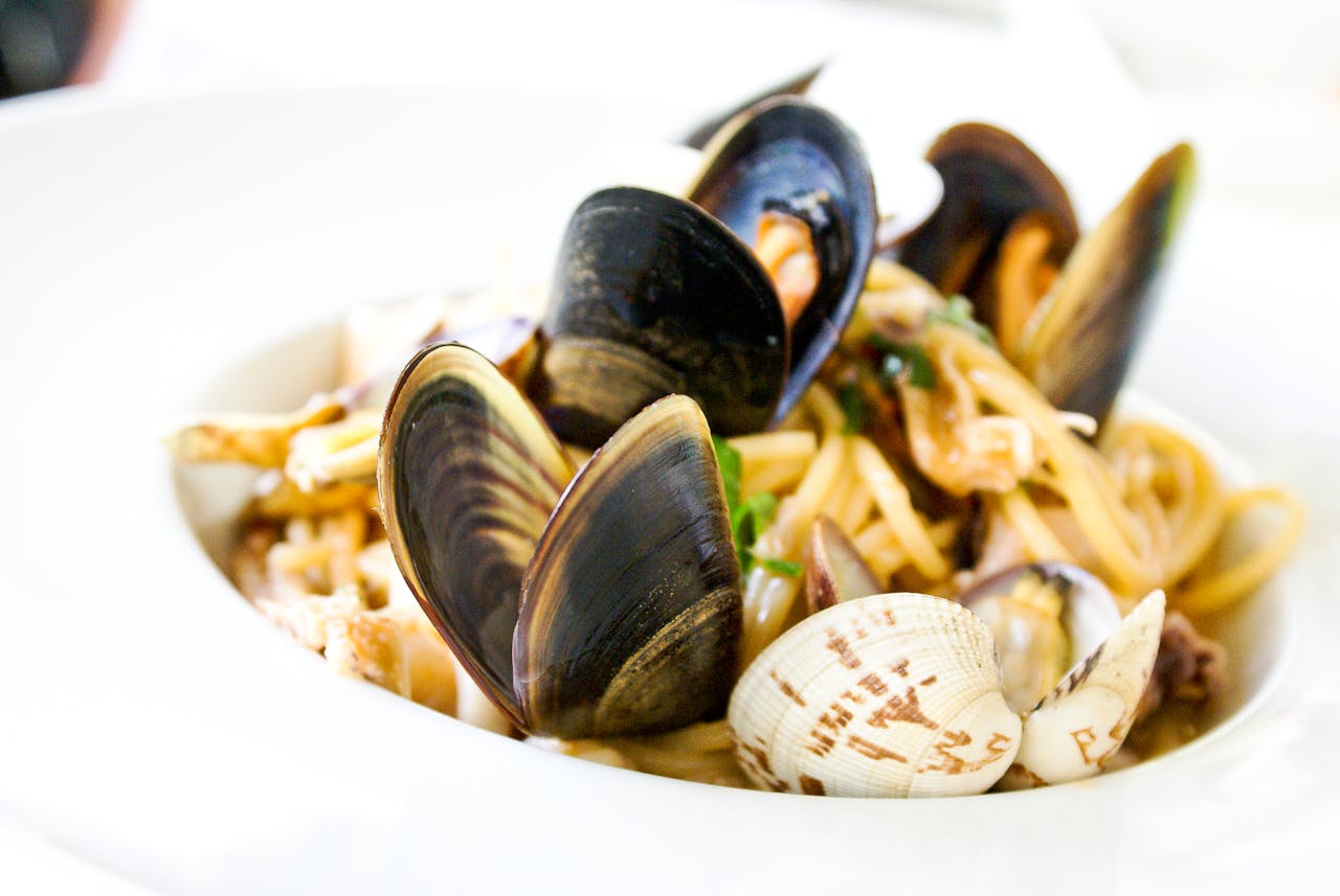 heros-img Close-up of Italian seafood pasta with clams and mussels served in Florence.